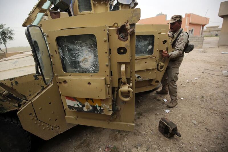 Iraqi soldiers stand next to their vehicle in the village of Huleileh, north of Mosul during an offensive to retake the area from ISIL fighters. Ahmad Al-Rubaye / AFP