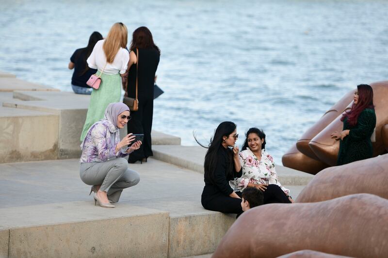 Visitors take photos near the giant sculpture.