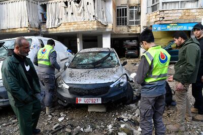 Members of the Civil Defense inspect a vehicle that was damaged near the building hit by a drone strike in the southern suburb of Beirut, Lebanon, 03 January 2024.   EPA / STRINGER
