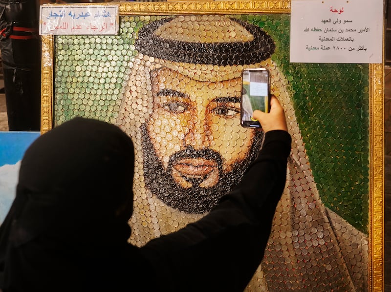 A visitor takes a video of an artwork by artist Hesham Abd Rabbouh, which consists of 2,800 coins forming the image of Saudi Crown Prince Mohammed bin Salman, during the Jeddah Season cultural festival, in Saudi Arabia.  