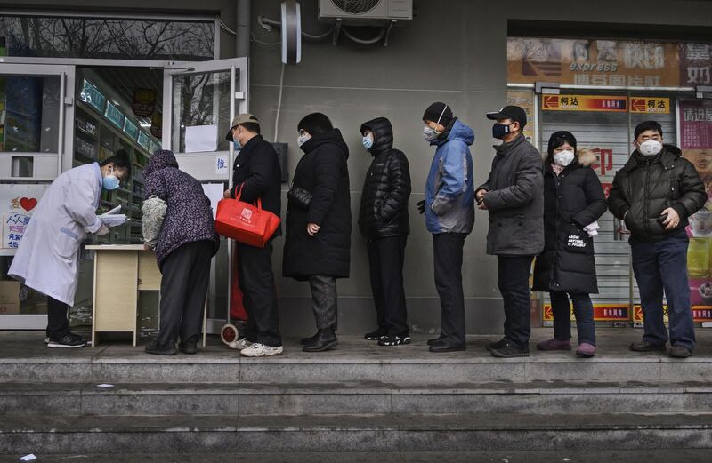 Chinese residents line up to get a free protective mask at a local pharmacy in Beijing, China. Getty Images