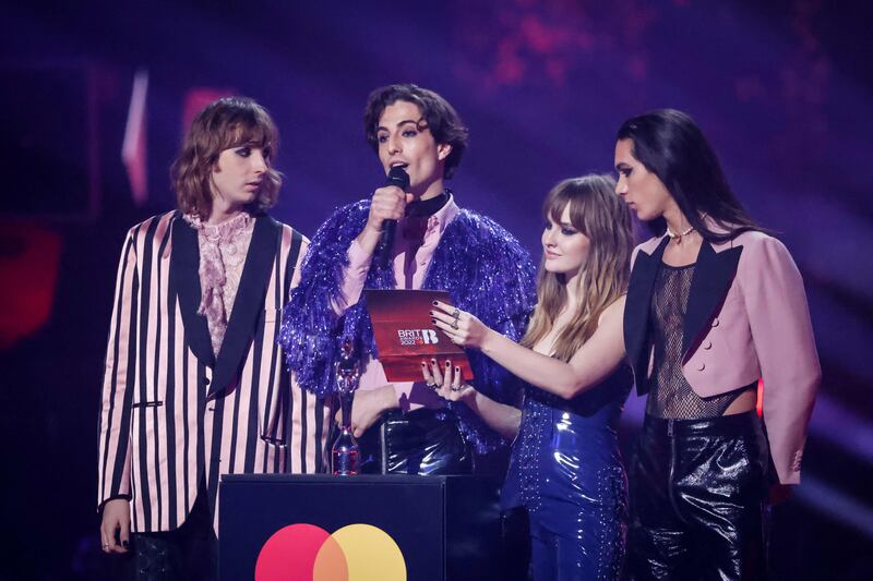 Italian rock band Maneskin presents an award. AFP