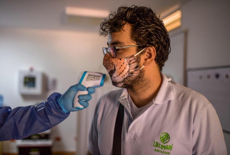 An employee of the Ukumari Biopark has his temperature taken in Pereira, in western Colombia. AFP