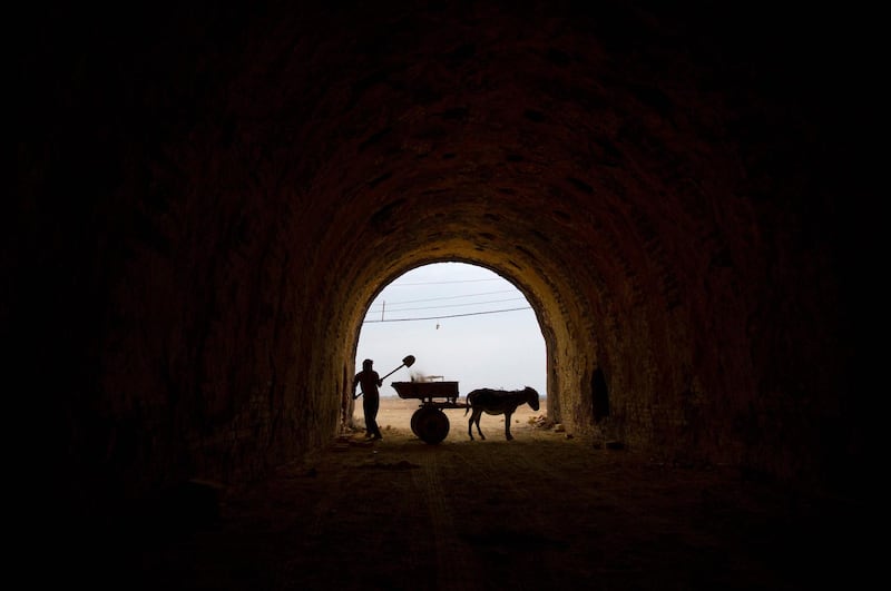 A worker fills a donkey cart with soil to make bricks.  AFP