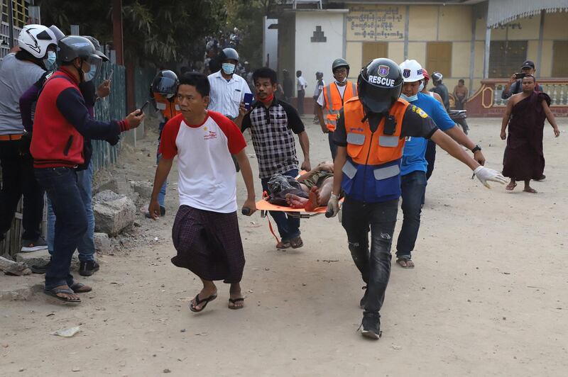 A wounded man is carried on a stretcher by a medical team after security forces opened fire on protesters during a demonstration against the military coup in Mandalay. AFP