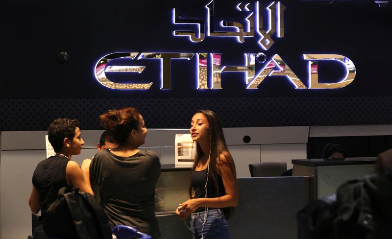 Passengers check into a flight at Abu Dhabi International Airport. On Wednesday morning travellers bound for the US were allowed to carry their electronic devices after the ban was lifted. Jon Gambrell / AP Photo