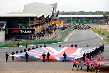 FILE PHOTO: Formula One F1 - British Grand Prix - Silverstone Circuit, Silverstone, Britain - July 14, 2019 General view of a Union Jack flag being carried out on to the track by service personnel before the race REUTERS/John Sibley/File Photo