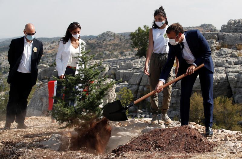French President Emmanuel Macron plants a cedar next to members of the NGO Jouzour Loubnan in Jaj, Lebanon.  EPA