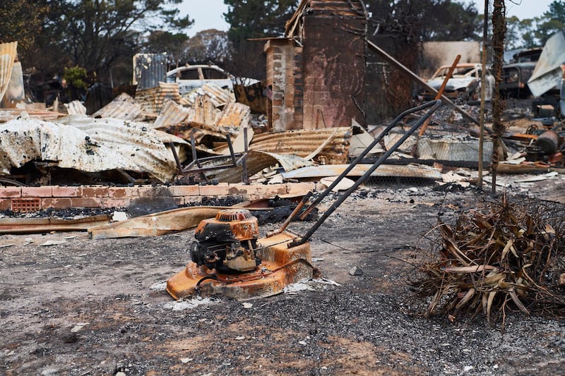 A burnt lawn mower is pictured outside a destroyed structure in Wingello, Australia. Getty Images