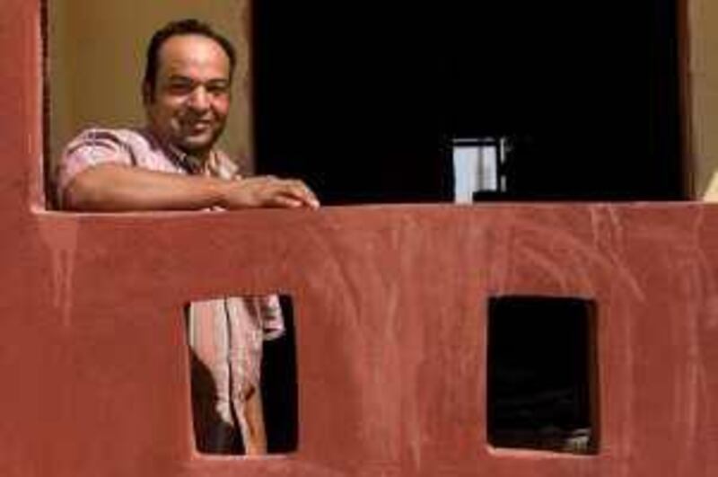 Ashraf Abaz, 38 years old, stands on a cupola in his new home, a three-story dwelling he is building through the Egyptian government's Ibni Baitak, or "My Son's House," program in Sixth of October City, near Cairo, Egypt, July 14, 2009. The new program is designed to shift low-income people from population-dense, inner-city Cairo to a less densely populated suburb outside Cairo. The government gives each successful applicant a piece of land for the price of 10,000 Egyptian pounds, then it is up to the owner to build a three-story home. Once the tightly supervised project is finished, the owner of the land and house is allowed to rent or sell two of the three floors as apartments. The Ministry of Housing hopes the program will give low-income people a boost into the middle class. *** Local Caption ***  HPibni_baitak04.jpg