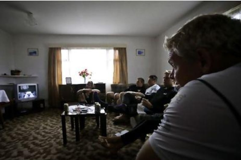 Tony Mutter and crew watching TV in the team's Tristan da Cunha housing.