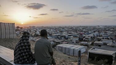 Palestinians displaced by the Israeli air and ground offensive on the Gaza Strip sit at a temporary camp housing thousands of families, in Khan Younis. AP
