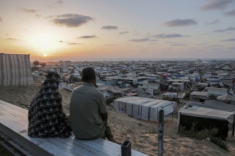 Palestinians displaced by the Israeli air and ground offensive on the Gaza Strip sit at a temporary camp housing thousands of families, in Khan Younis. AP