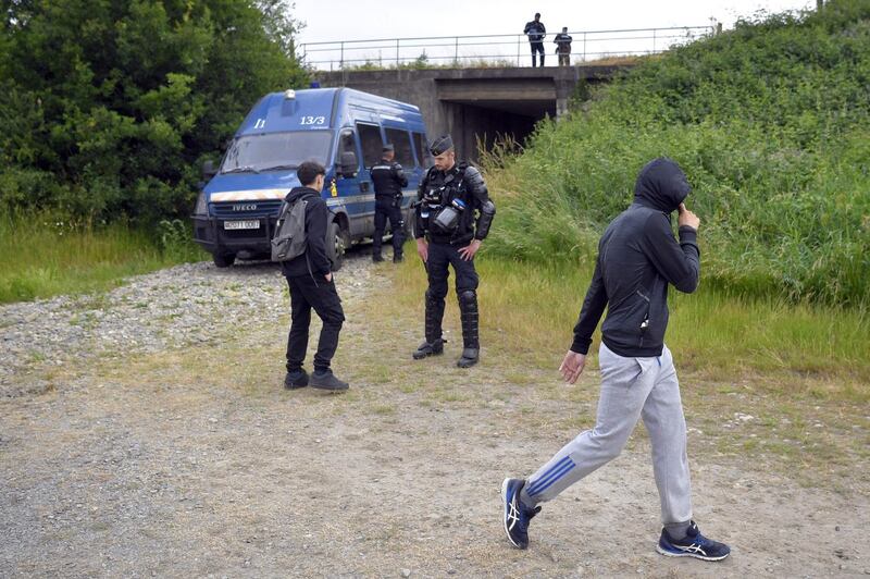 Participants of an illegal rave party speak with French gendarmes, in Redon, north-western France, on June 19, 2021. Five police officers were injured overnight in western France as they broke up a 1,500-strong illegal rave, authorities said on June 19, 2021, with one partygoer losing a hand in the clashes. Defying an 11 pm coronavirus curfew, the group had attempted to set up the party at a horse racing track near Redon in Brittany.  / AFP / LOIC VENANCE
