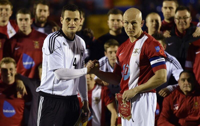 British Army football captain Sergeant Keith Emmerson, right, shakes hands with his German counterpart, Bundeswehr captain Alfred Hess, before their teams played the "Game of Truce" on Wednesday in Aldershot, England. Toby Melville / Reuters