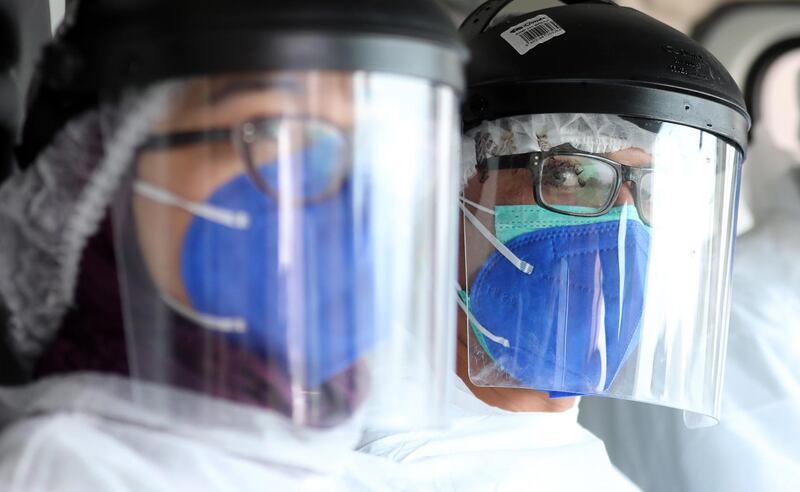 Members  of Tunisia's Urgent Medical Aid Service wear protective equipment before visiting coronavirus patients in Tunis.  EPA