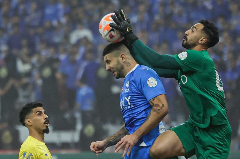 Al Nassr goalkeeper Nawaf Al Aqidi catches the ball above Al Hilal's Aleksandar Mitrovic. AFP