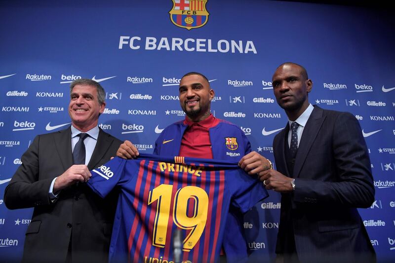 Barcelona's new Ghanaian forward Kevin-Prince Boateng poses with Barcelona's technical secretary Eric Abidal, right, the club's vice president Jordi Mestre. AFP