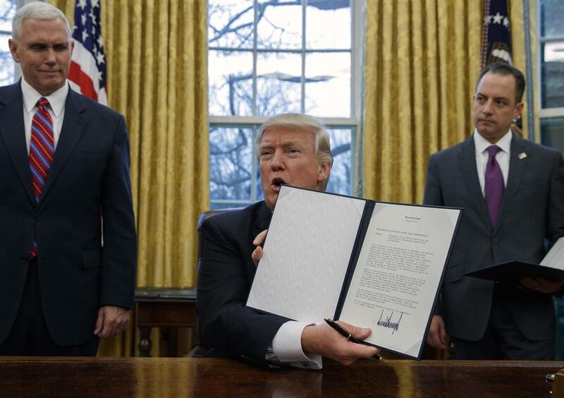 The US president Donald Trump shows off an executive order to withdraw the country from the Trans-Pacific Partnership trade pact. Evan Vucci / AP Photo