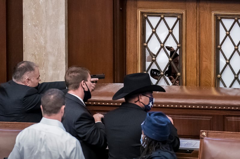 Security agents and members of Congress barricade the door to the House chamber as the violent mob breaches the Capitol. AP