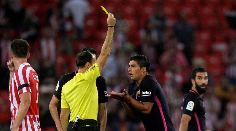 Barcelona’s Luis Suarez receives a yellow card. Vincent West / Reuters