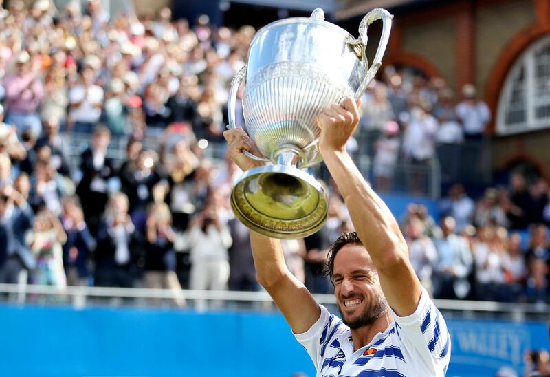 Spain's Feliciano Lopez celebrates with the trophy after winning the final against Croatia's Marin Cilic at The Queen's Club tennis tournament in London, Sunday June 25, 2017. (Steven Paston/PA via AP)
