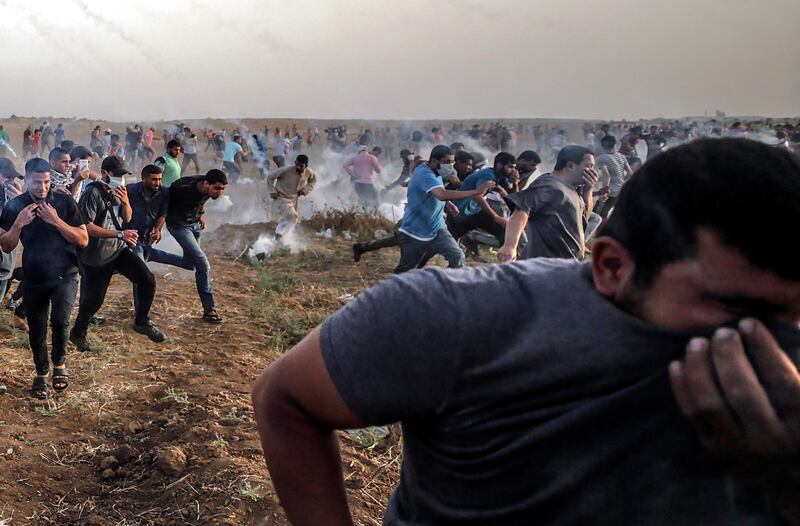 epaselect epa06763718 Palestinians protesters run for cover from Israeli tear-gas during the clashes near the border between Israel and Gaza Strip, eastern Gaza City on, 25 May 2018. More than 120 Palestinians protesters have been injured during the clashes near the border with Israel, Protesters plan to call for the rights of Palestinian refugees across the Middle East to return to homes they fled in the war surrounding the 1948 creation of Israel.  EPA/MOHAMMED SABER