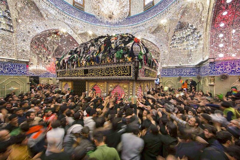 Shiite pilgrims reach out to touch the tomb of Imam Al Abbas located inside the Imam Al Abbas shrine in the holy city of Kerbala on December 13. Reuters