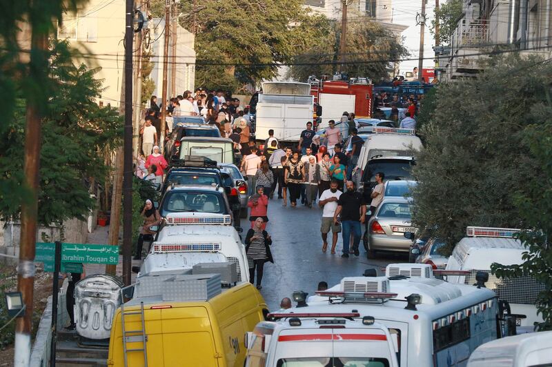 Emergency personnel and residents gather in an area near where the building collapsed. AFP