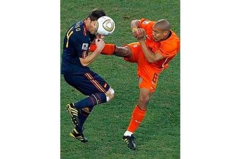 Spain's Xabi Alonso, left, gets kicked in his chest by Netherlands' Nigel de Jong as they fight for the ball.