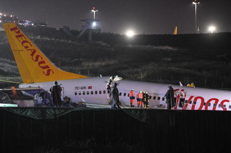 Turkish soldiers stand guard as rescuers work to extract passengers from the crash of a Pegasus Airlines Boeing 737 airplane, after it skidded off the runway upon landing at Sabiha Gokcen airport in Istanbul.  AFP
