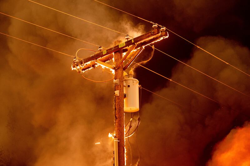 Fire burns an electricity pole as blazes tear through Doyle, California.