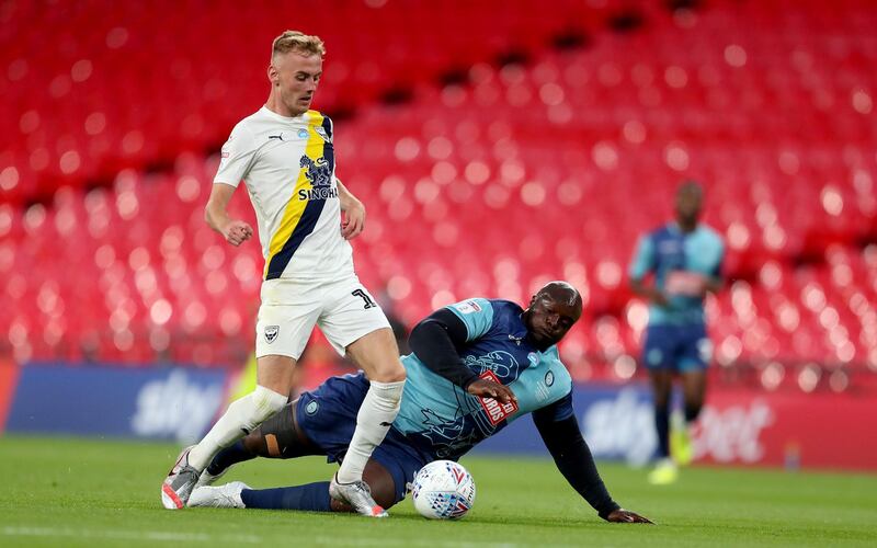 Mark Sykes of Oxford United is challenged by Adebayo Akinfenwa of Wycombe Wanderers. Getty