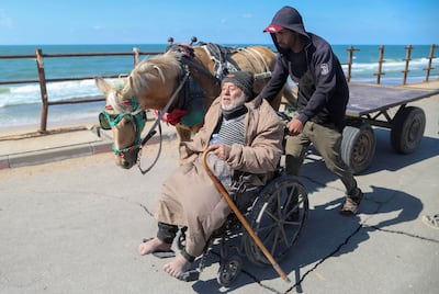 A Palestinian man sitting in a wheelchair is assisted while fleeing north Gaza, following an Israel raid on Al Shifa Hospital. Reuters