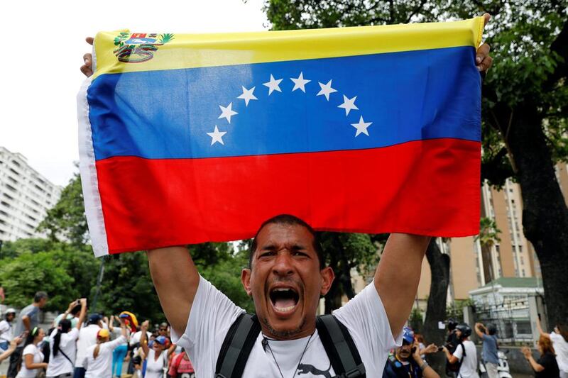 A demonstrator holds a Venezuelan flag as he takes part in a protest against Venezuela’s President Nicolas Maduro’s government in Caracas. Carlos Garcia Rawlins / Reuters