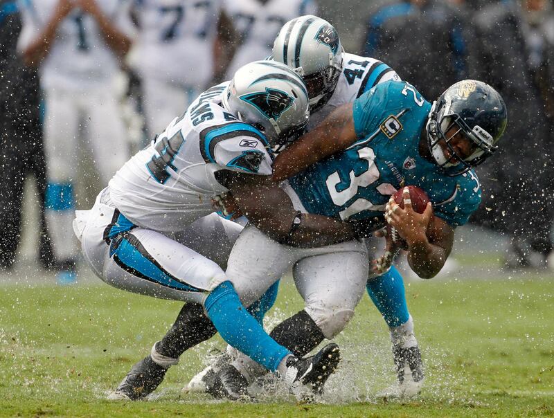 Jacksonville Jaguars' Maurice Jones-Drew (32) is tackled by Carolina Panthers' Captain Munnerlyn (41) and  Jason Williams (54) during the third quarter of an NFL football game in Charlotte, N.C., Sunday, Sept. 25, 2011. (AP Photo/Bob Leverone) *** Local Caption ***  Jaguars Panthers Football.JPEG-0adb3.jpg