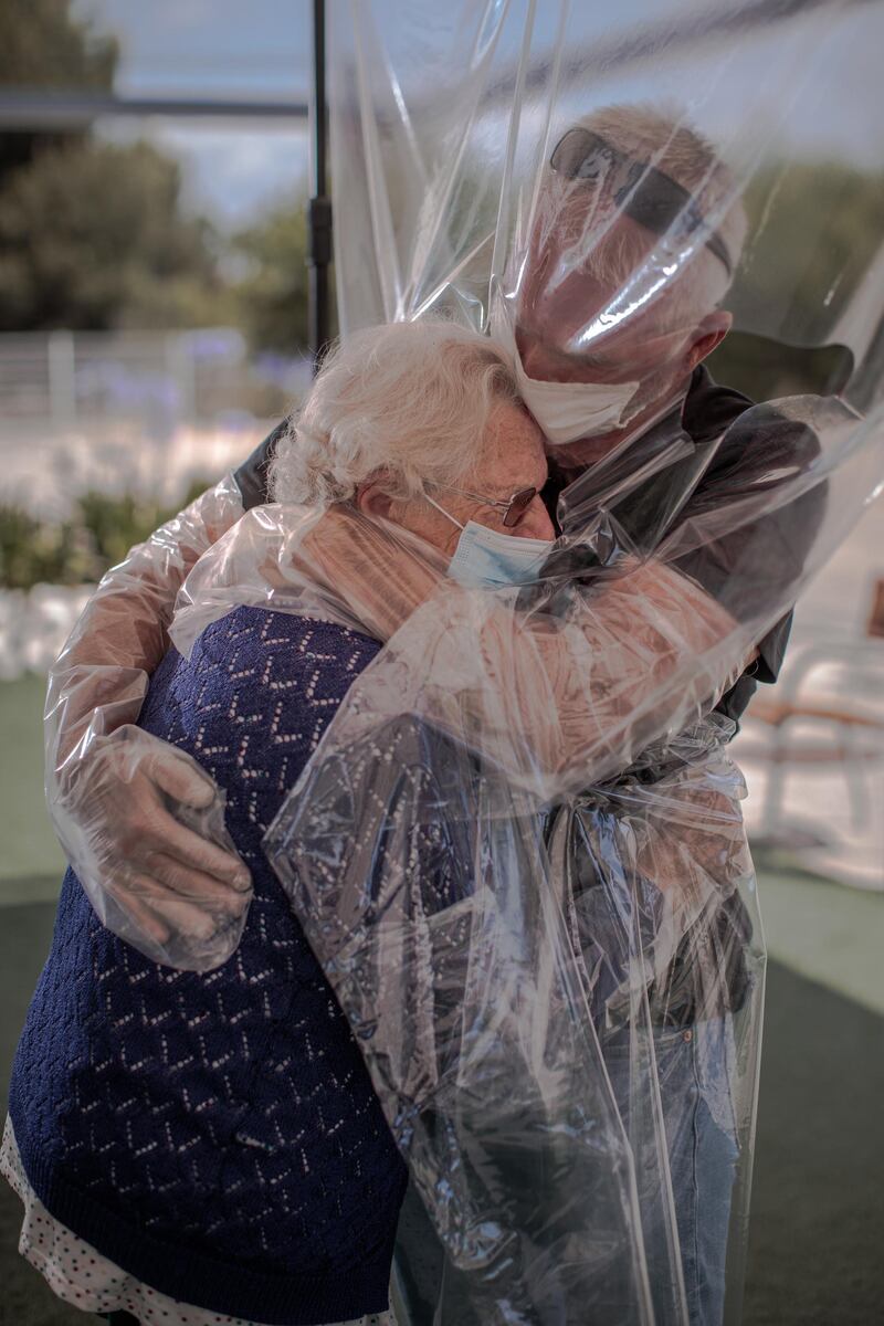 A woman embraces her son through a plastic device after three months without a hug at a home for the elderly in Valencia, Spain. EPA