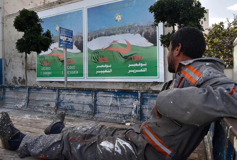 An Algerian worker looks at campaign billboards ahead of the referendum in November which will vote constitutional reforms in Algiers. AFP