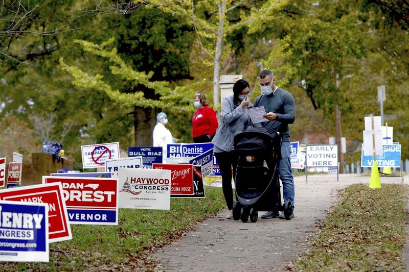 Voters look over a sample ballot handed to them by a volunteer as they arrive at a polling place in Winston-Salem, North Carolina.  AFP