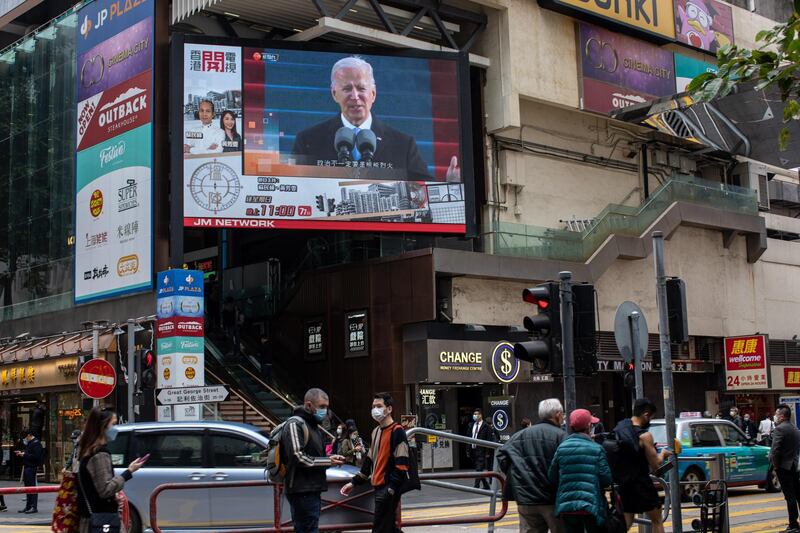 epa08954777 Pedestrians walk past an electronic billboard showing US President Joe Biden in Hong Kong, China, 21 January 2021. Biden was sworn in as the 46th President of the United States of America on 20 January 2021.  EPA/JEROME FAVRE