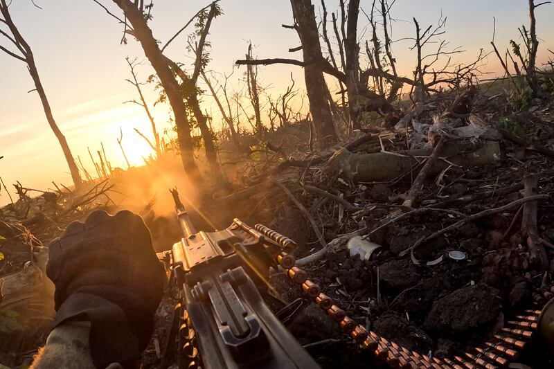 A Ukrainian soldier fires a machinegun towards Russian positions near Bakhmut. Experts say the fierce battle for the eastern city has allowed Ukraine to make progress elsewhere. AP