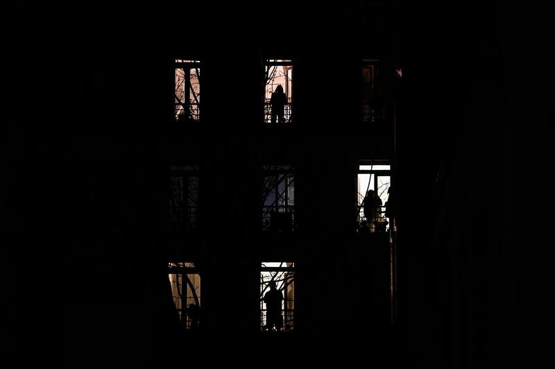 People stand by their windows and applause in solidarity with healthcare workers on the frontline of the coronavirus outbreak gripping the country in Paris. AFP