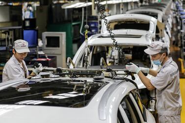 Employees at a car assembly line in Wuhan - the OECD on Wedensday revised upward its global economic contraction forecast on a quicker recovery in China and the US - the world's two largest economies. AFP 