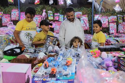 A man and his children buy toys in preparation for Eid al-Fitr, marking the end of the Muslim fasting month of Ramadan, following the outbreak of the coronavirus disease (COVID-19), in Misrata, Libya May 19, 2020. Picture taken May 19, 2020. REUTERS/Ayman Al-Sahili