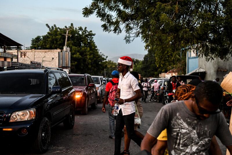A man walks on the street wearing a Santa Claus hat during Christmas eve in Port-au-Prince.  AFP