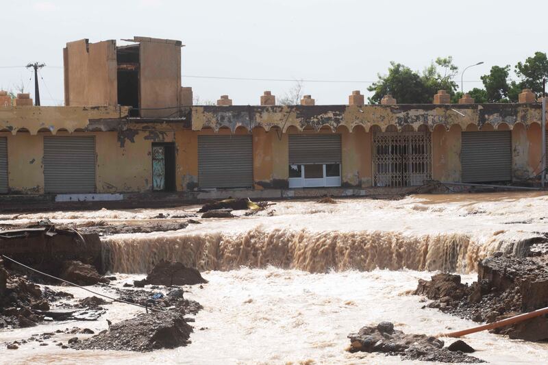 A torrent of floodwater runs through Al Khaburah. Photo: EPA