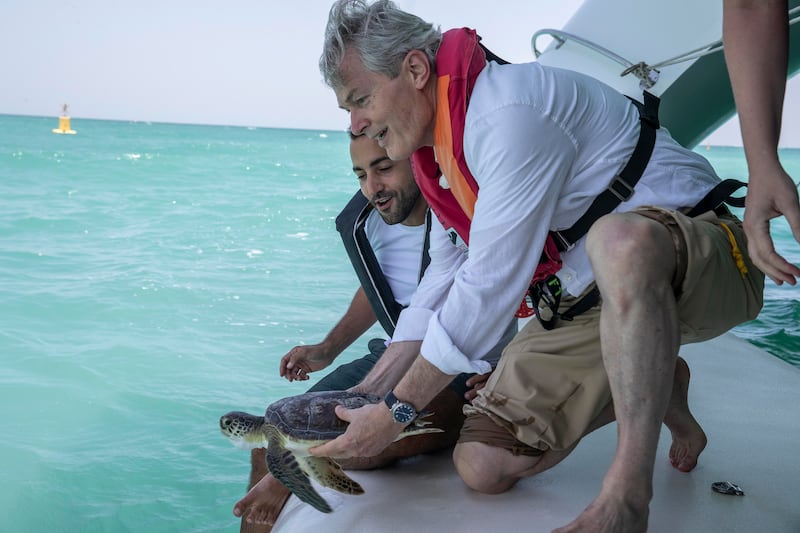 President of the Porrima Foundation, Prof Gunter Pauli, releases a turtle into the water. Antonie Robertson / The National
