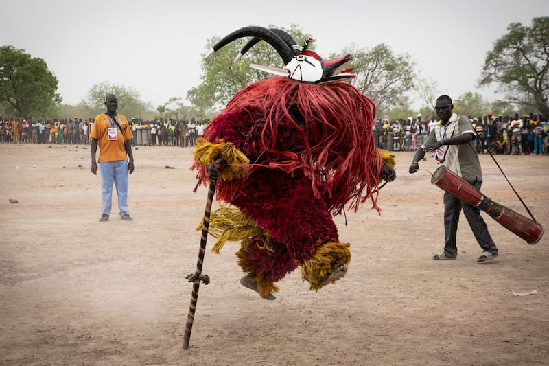 A traditional mask dances during the Festimasq, the Festival des Masques in Pouni, Sanguie province, on March 30, 2024.  To the jerky rhythm of drums and flutes, hundreds of people parade in Pouni, a rural commune in Burkina Faso, wearing large colorful masks: in this country undermined by jihadist violence, these mystical objects of transmission must now call for peace.  (Photo by FANNY NOARO-KABRÉ  /  AFP)