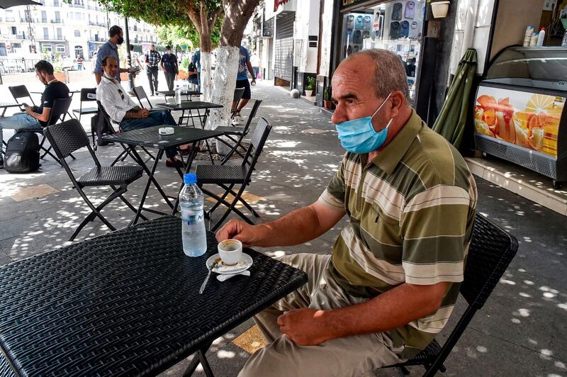 A patron sits at a cafe in the centre of Algeria's capital Algiers, as the country eases Covid-19 restrictions. AFP