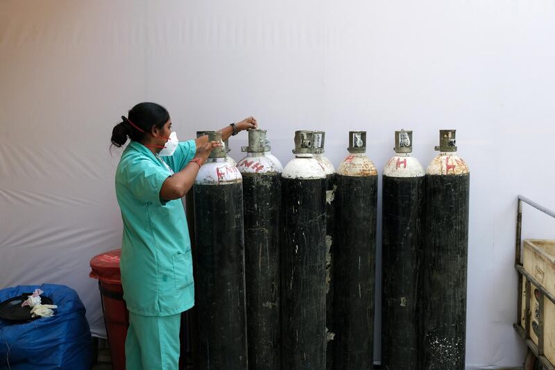 A health worker check oxygen cylinders at a makeshift Covid-19 quarantine facility set up in a banquet hall in New Delhi, India, on Tuesday, April 13, 2021. India is now the world’s second worst-hit nation, having overtaken Brazil once again Monday with a sharp jump up in daily new infections. Photographer: T. Narayan/Bloomberg